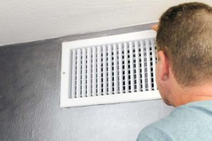 Man looking into air vent